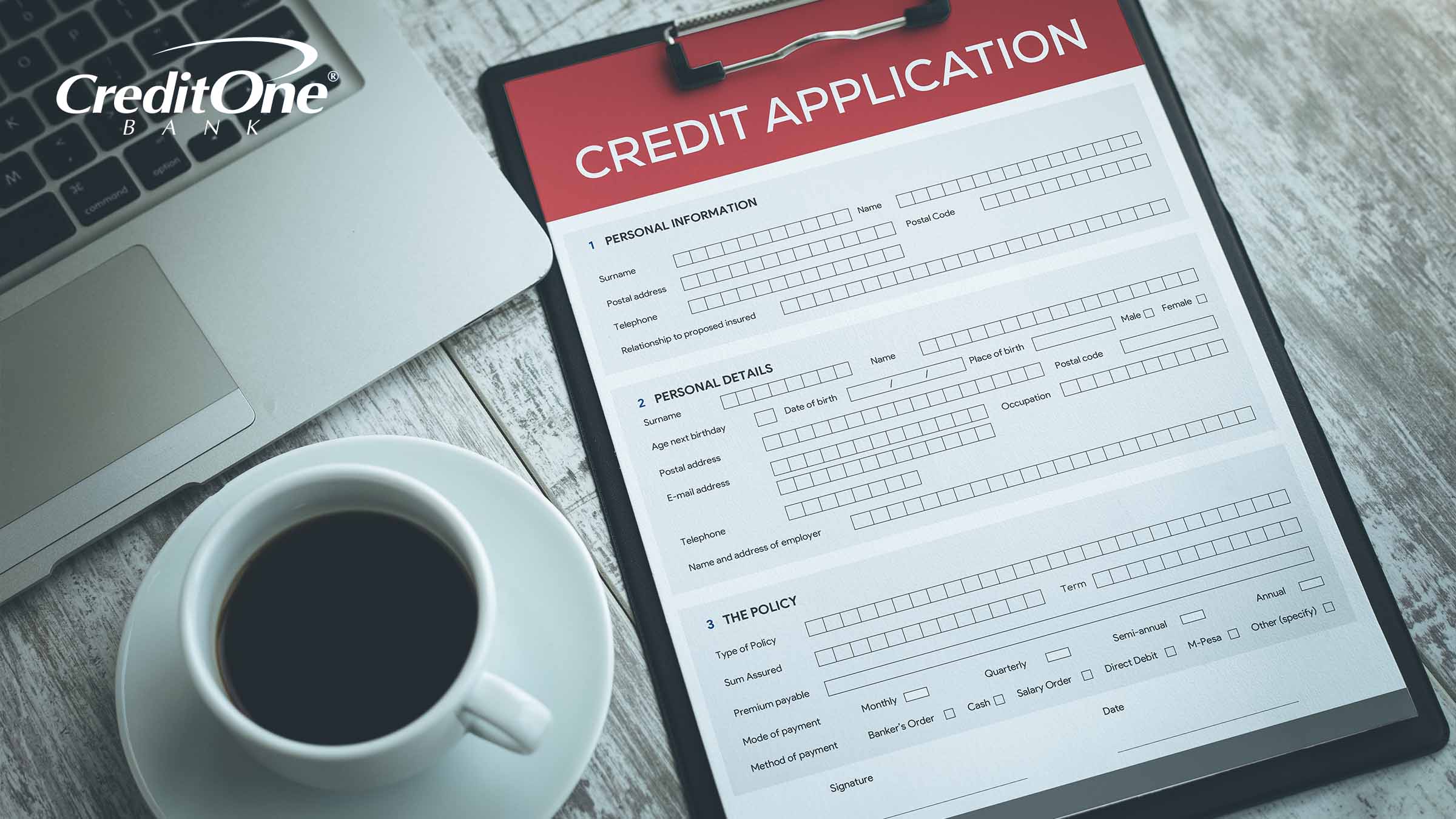 A laptop and cup of coffee sit beside a clipboard with credit application. When submitted, the applicant will undergo a credit inquiry.